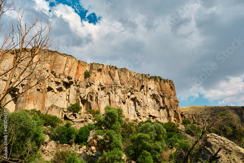 Canyon photo, sun reflection and cloudscape over huge stone of canyon in ihlara valley, turkey.