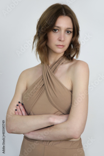 Serie of photos of female model wearing beige multi wear wrap around tank top from organic cotton and basic pants.