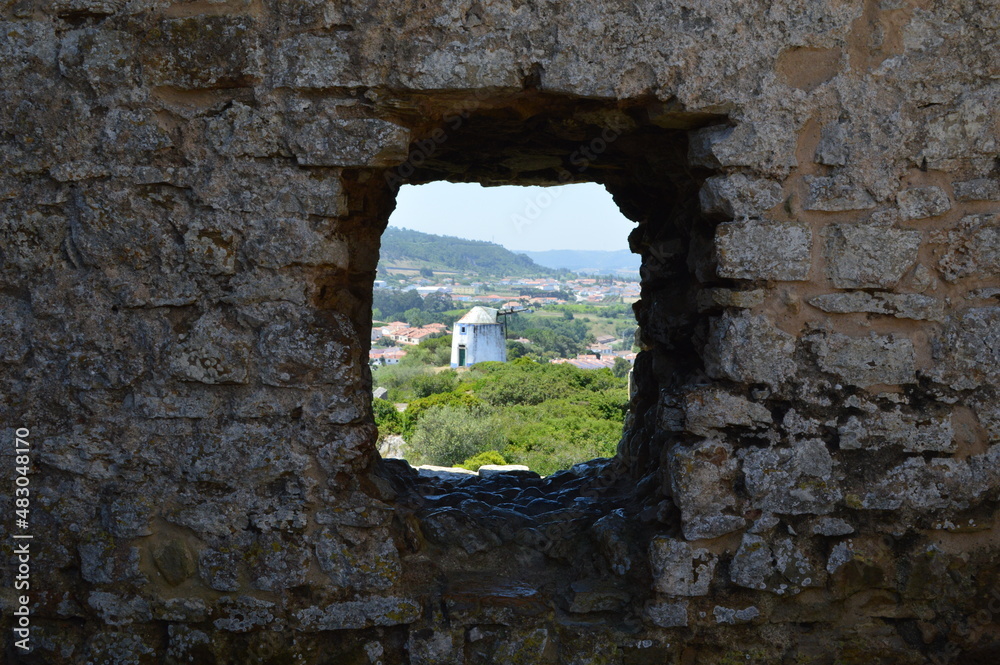 old windmill through ruins of the castle
