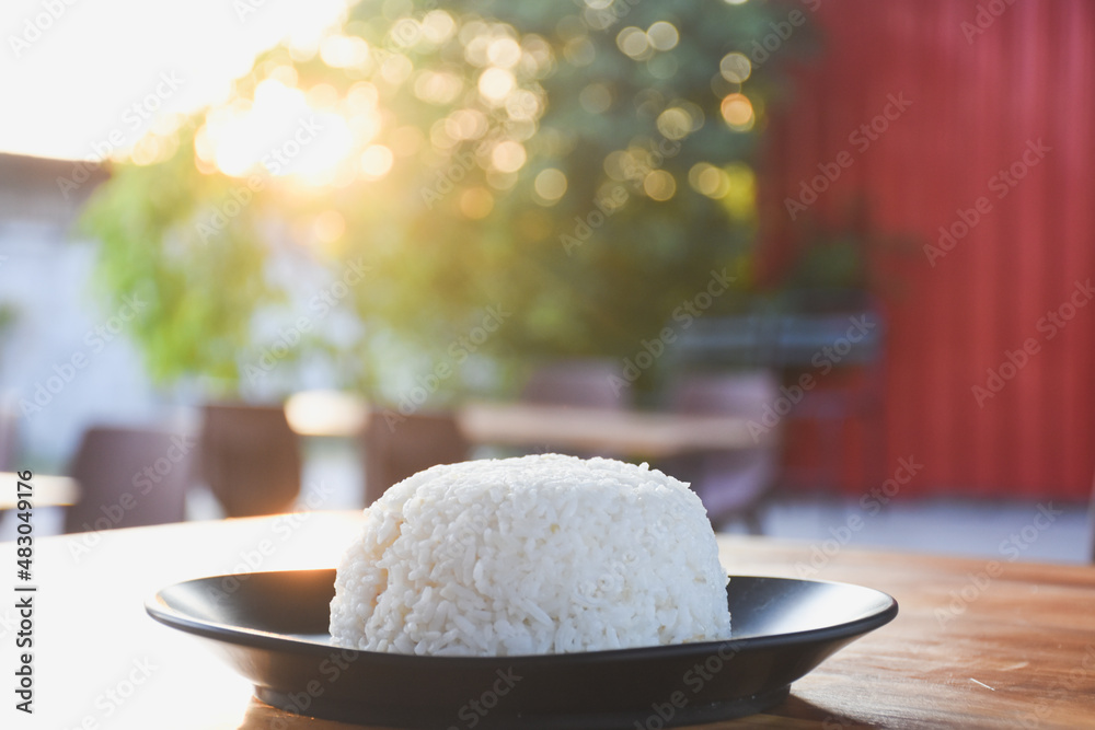 Plain rice on a black plate on the table Plain rice on a black plate on the table