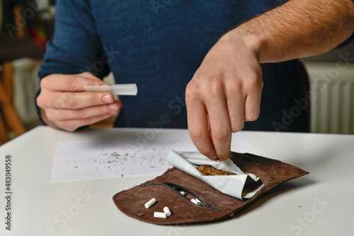 Male hand rolling cigarette photo