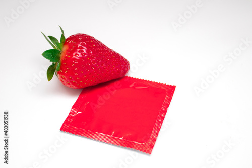 Strawberry with red condom on white background. Sex concept