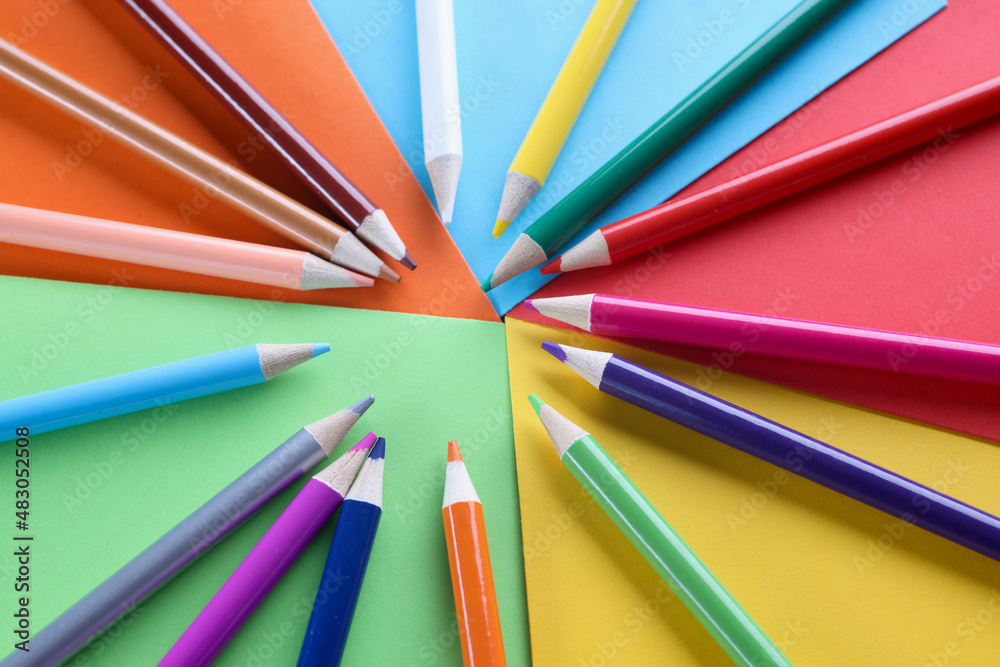 Lot of sharp wooden pencils lying on multicolored background closeup Lot of sharp wooden pencils lying on multicolored background closeup