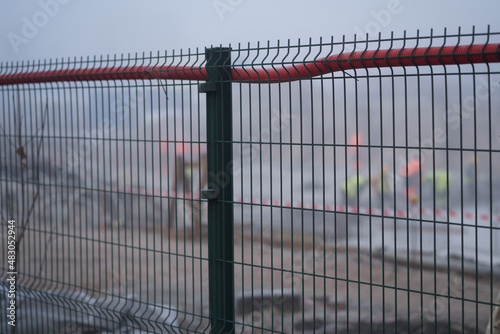 The fence behind which the multi-storey house construction process takes place