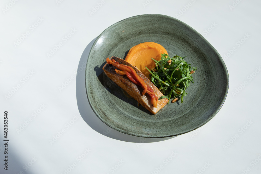 Grilled steak meat salmon with baked potatoes and green salad with dip sauce. Delicious full dinner.