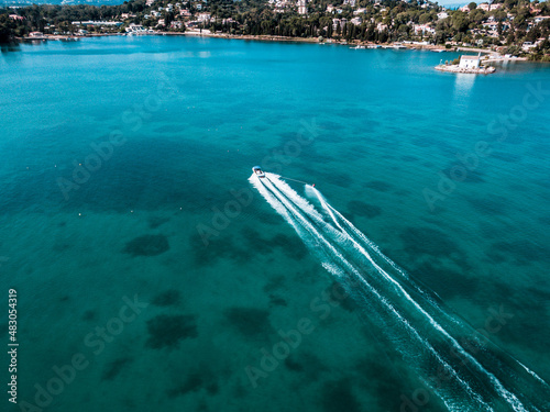 Aerial photo of extreme power boat water-sports cruising in high speed in deep blue corfu island greece