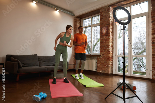 Couple exercisee on fitness mats for video at home photo