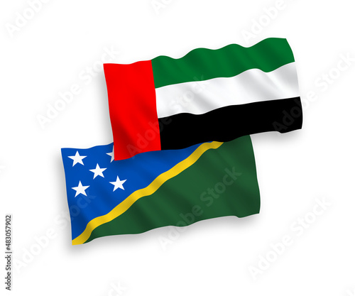 National vector fabric wave flags of Solomon Islands and United Arab Emirates isolated on white background. 1 to 2 proportion.