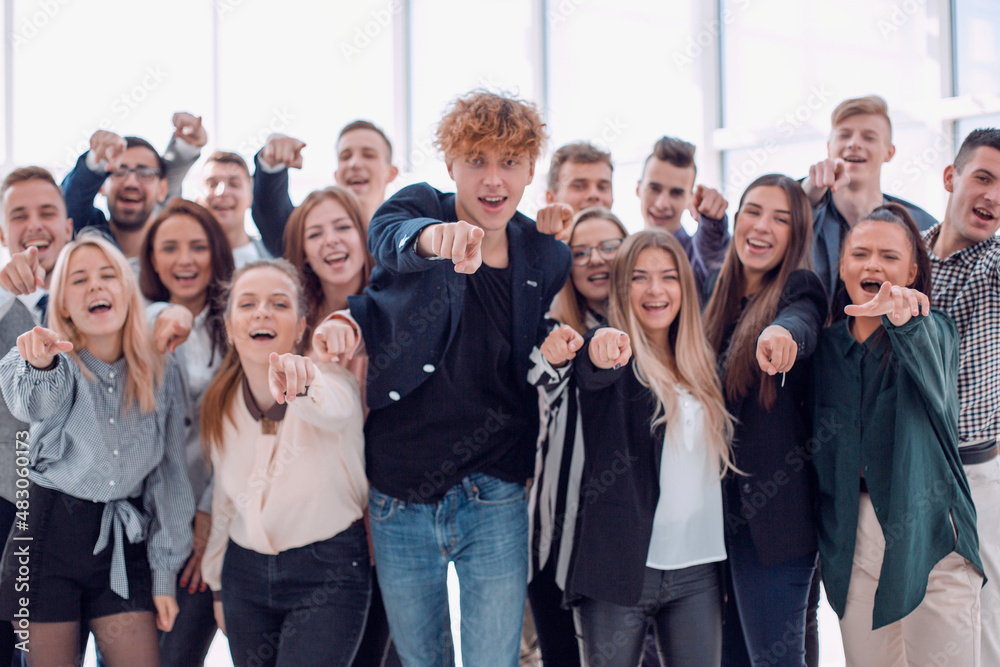 team of happy young men pointing at the camera.