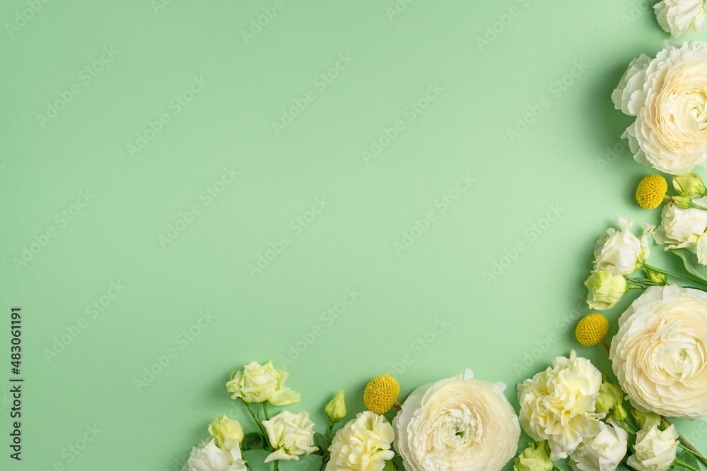 Tender fresh white and yellow flowers on light green background. Seasonal floral composition. Spring blossom holiday mockup. Ranunculus, chrysanthemum, eustoma. Copy space, top view, flat lay.