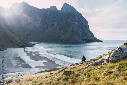 Obraz na płótnie Relaxed man sitting watching a sunset on a beach in norway w salonie