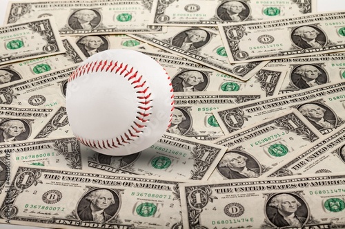 Baseball ball with cash money. Major league strike, lockout and sports betting concept.