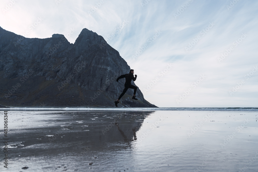 man jumping on the beach in norway