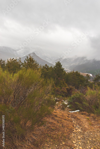 A picturesque landscape view of a hiking path in the French Alps mountains during the rain on a cold winter day (Veynes, Chateauvieux) photo