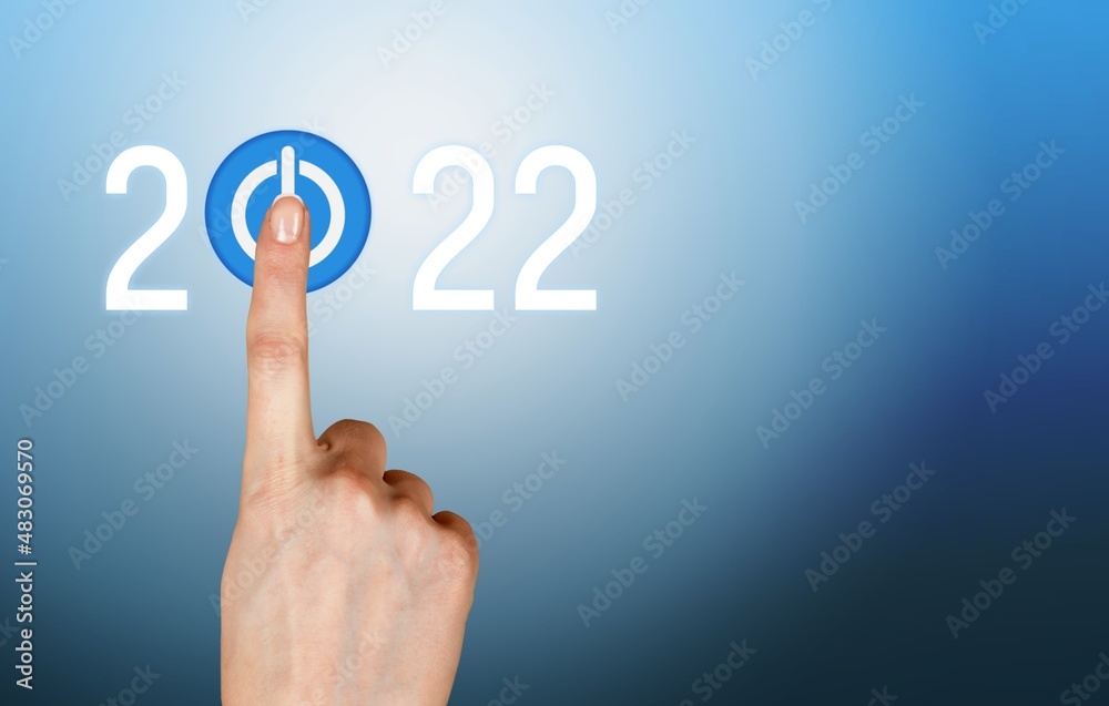 hand presses the start button for 2022. Happy New Year resolution, change, goal, vision, hand presses the start button for 2022. Happy New Year resolution, change, goal, vision,