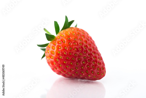 Fresh organic strawberries on a white reflective surface. Close up shot.