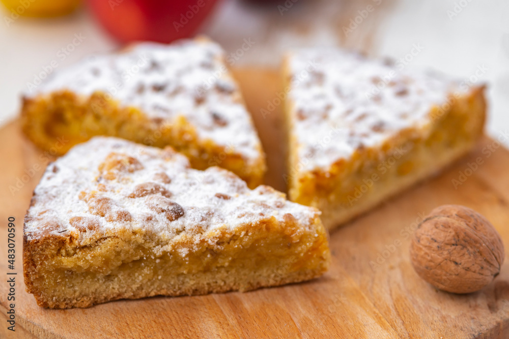 apple and nuts pie on wooden desk on white table