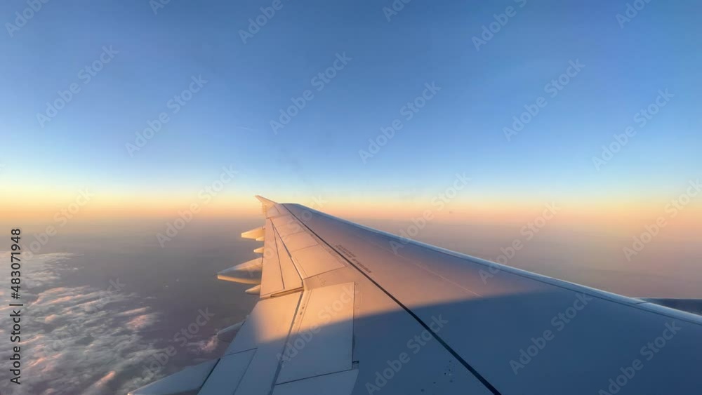 views from the window of an airplane in mid-flight, wing passing over the clouds take off