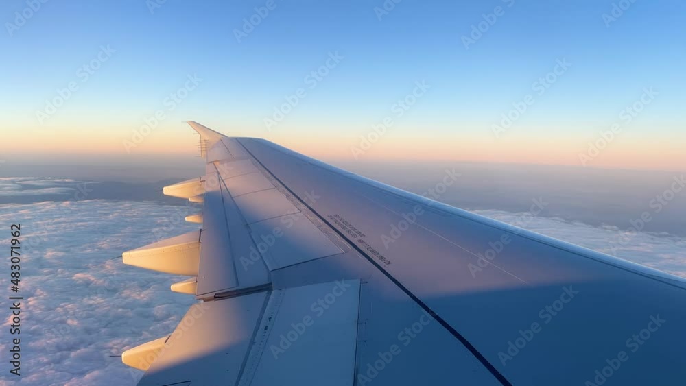 views from the window of an airplane in mid-flight, wing passing over the clouds take off views from the window of an airplane in mid-flight, wing passing over the clouds take off