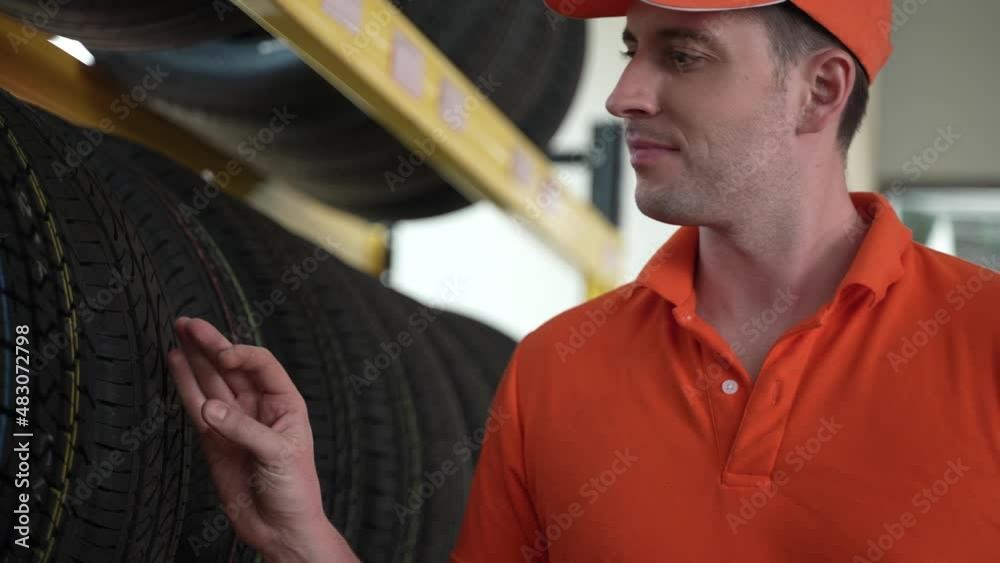Employees or customers are viewing tires. Buy auto parts and get vehicle inspection services in auto garage, choose a new tire for car