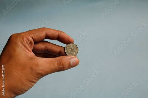 Close up hand holding twenty cent dollar coin singapore