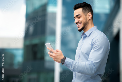Positive arabic businessman with mobile phone outdoors © Prostock-studio