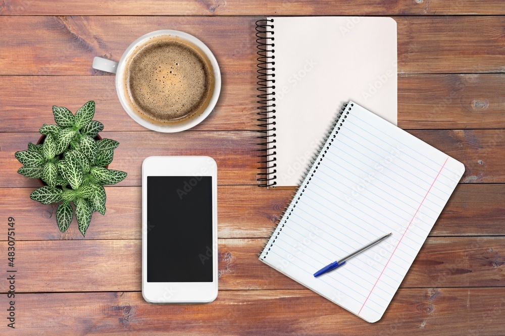 Office calendar, smartphone, cup of coffee and notebook on wooden background Office calendar, smartphone, cup of coffee and notebook on wooden background