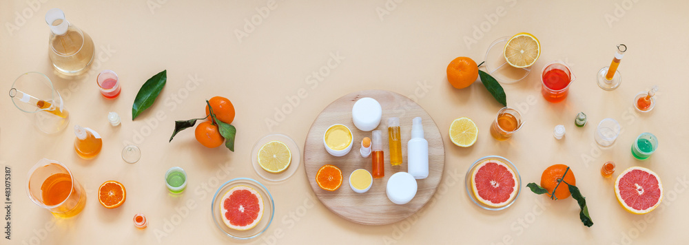 Panoramic top view on laboratory table with chemical glassware and natural cosmetics with citrus extracts on wooden podium. Presentation new cocmetics prodacts. Сoncept of cosmetology research Panoramic top view on laboratory table with chemical glassware and natural cosmetics with citrus extracts on wooden podium. Presentation new cocmetics prodacts. Сoncept of cosmetology research