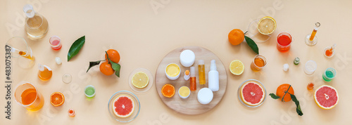Panoramic top view on laboratory table with chemical glassware and natural cosmetics with citrus extracts on wooden podium. Presentation new cocmetics prodacts. Сoncept of cosmetology research photo