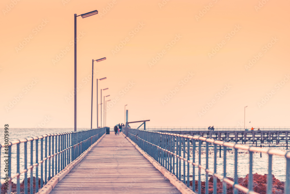 Partially defocused view of Moonta Bay jetty with people at dusk, Yorke Peninsula, South Australia