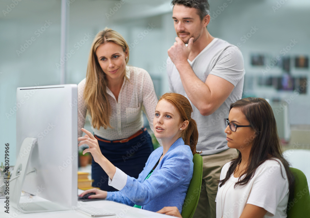Wow look at all we've done. Shot of a group of colleagues looking at a ...