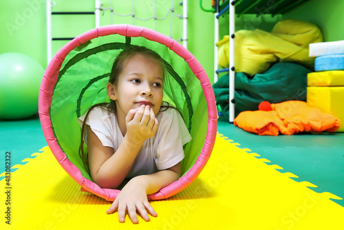 girl child in a special room plays and works on equipment for the treatment of problems with socialization in modern society