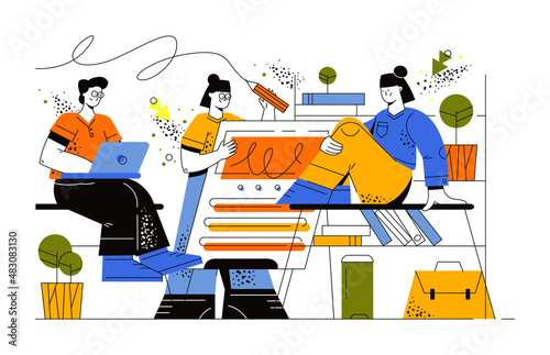Students sit in class and communicate with each other. The girl is sitting at the table. The young man looks at his laptop. Girl holding a pencil in her hand and writing on a digital blackboard.