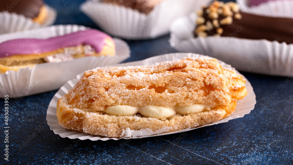 Beautiful delicious French eclairs with custard, covered with multi-colored icing. Beautiful delicious French eclairs with custard, covered with multi-colored icing.