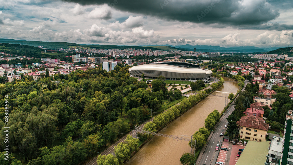 Aerial view of a city park with a river on a cloudy day.