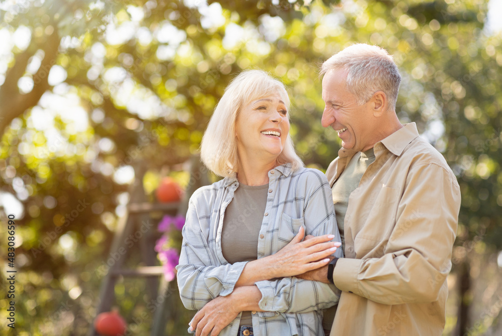 Loving retired spouses enjoying time together in park, walking at sunny autumn day, man embracing her wife, free space Loving retired spouses enjoying time together in park, walking at sunny autumn day, man embracing her wife, free space