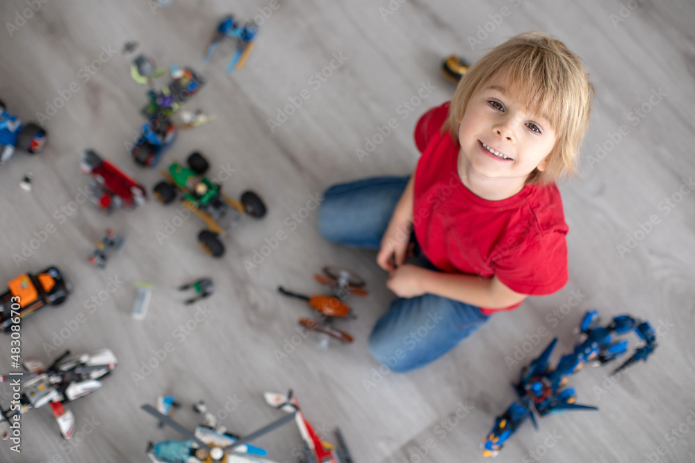 Cute toddler child, blond boy, playing with colofrul plastic blocks, construction toys Cute toddler child, blond boy, playing with colofrul plastic blocks, construction toys