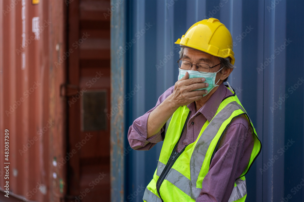 Elderly Asian man wearing a mask works container cargo handling ...