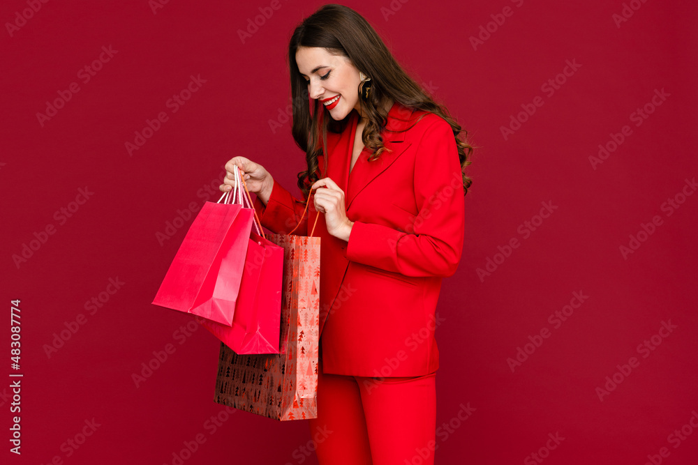 attractive woman in red with shopping bags sale on red background Saint Valentine's Day attractive woman in red with shopping bags sale on red background Saint Valentine's Day