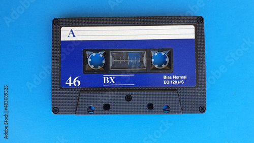 Retro audio cassette tapes on blue background. Vintage media device. Space to write on the label.