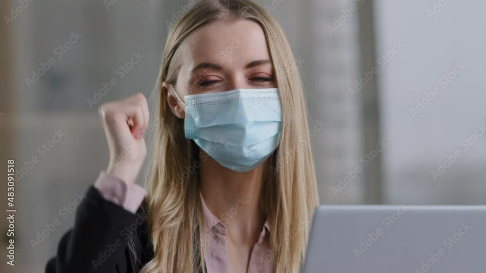 Caucasian business woman worker freelancer student manager female boss wearing medical mask in office working with laptop looking at camera showing thumb up recommends covid coronavirus protection Caucasian business woman worker freelancer student manager female boss wearing medical mask in office working with laptop looking at camera showing thumb up recommends covid coronavirus protection
