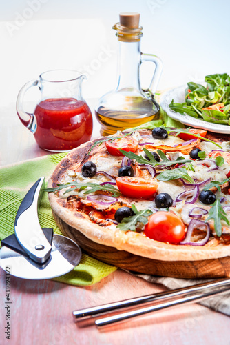 Pizza with ham, tomatoes  and arugula