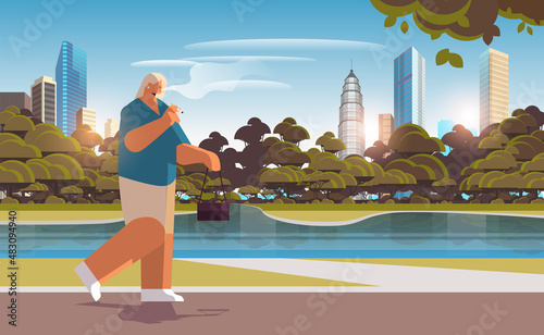 woman walking in park and smoking cigarette bad habits unhealthy lifestyle nicotine addiction no smoking concept
