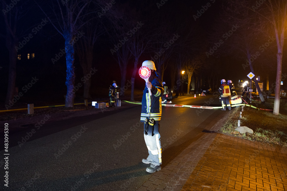 Feuerwehrmann sperrt Straße ab