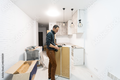 Worker installing new countertop in modern kitchen
