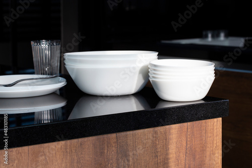 Set of clean dishes on black marble table.