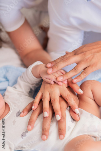 parents and baby holding hands, united family