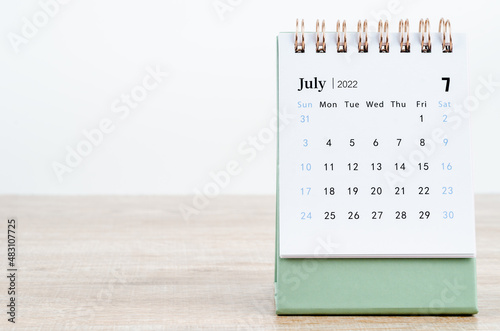 July 2022 desk calendar on wooden background. photo