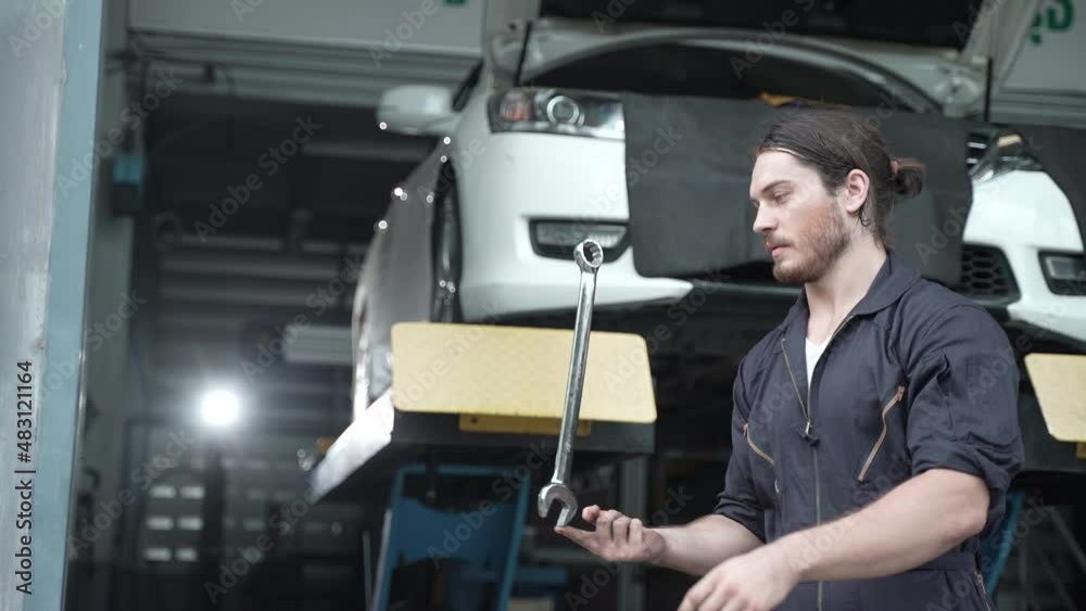 mechanic technician showing a wrench in shop automobile garage service, vehicle transportation maintenance and auto repair tool, man person occupation in slow-motion action mechanic technician showing a wrench in shop automobile garage service, vehicle transportation maintenance and auto repair tool, man person occupation in slow-motion action