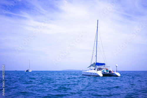 An island in the middle of the sea and a sailing boat on the sea